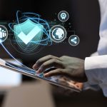 Manos escribiendo en computadora con gráfica de token inmobiliario, símbolo de inversión digital en propiedades reales.