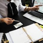 Joven profesional señalando un diseño digital en una computadora, representando la defensa de CAMESI por un mercado inmobiliario moderno, competitivo y transparente en Salta frente a la modificación de la Ley 7629.